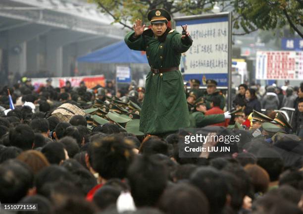 Chinese paramilitary soldier ties to keep order as passengers gather at the railway station, in China's southern city of Guangzhou, 01 February 2008....
