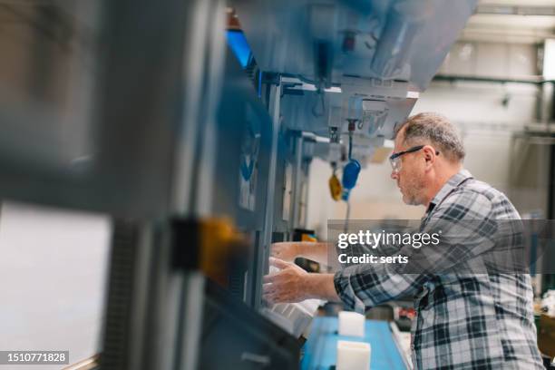 manual worker man working at manufacturing factory - vestido adornado imagens e fotografias de stock