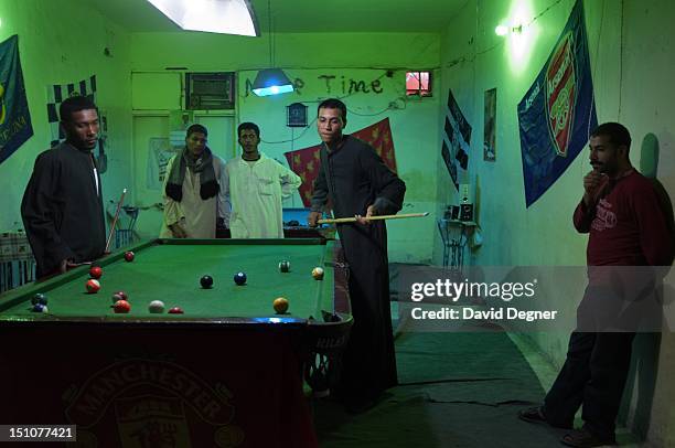 Young men who mainly came to Abo Simbel from other parts of Egypt for work play pool late into the night at a coffee shop in the middle of the town,...