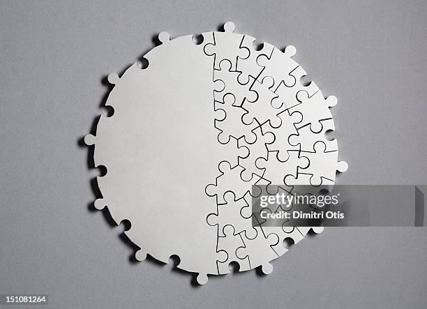 radiating silver puzzle, half united as one piece - jigsaw piece stockfoto's en -beelden