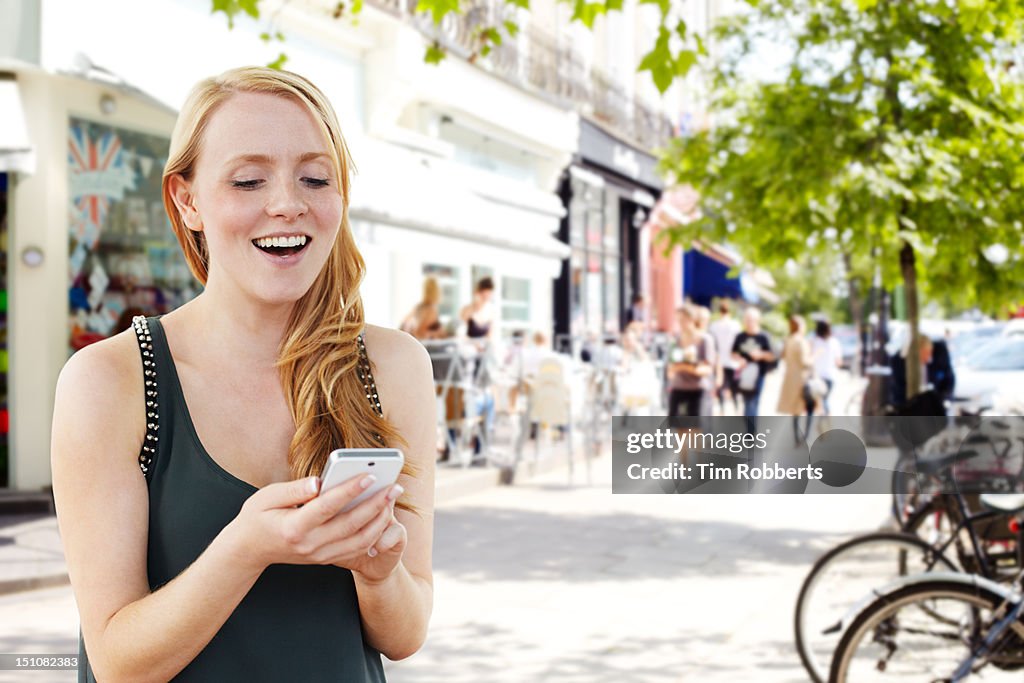 Young woman using smartphone on street