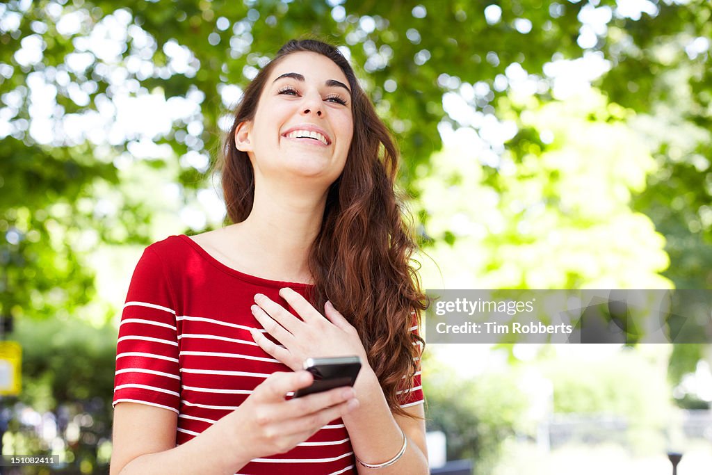 Young woman laughing with smart phone