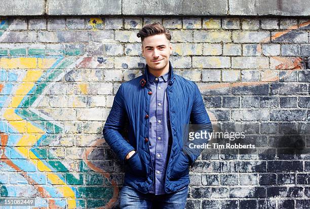 portrait of young man against wall. - handsome people stock pictures, royalty-free photos & images
