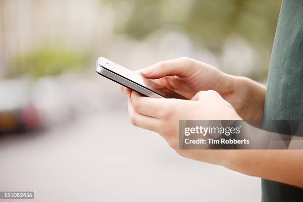 close up of young woman using smart phone. - tocar fotografías e imágenes de stock