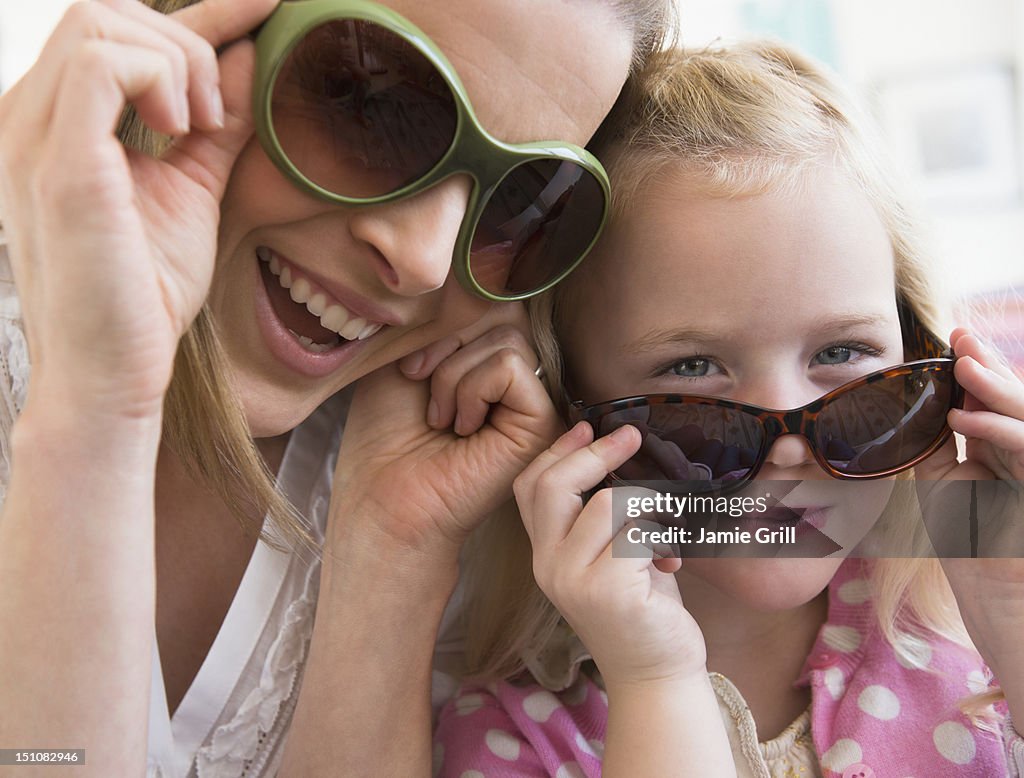 Mother and daughter wearing sunglasses together