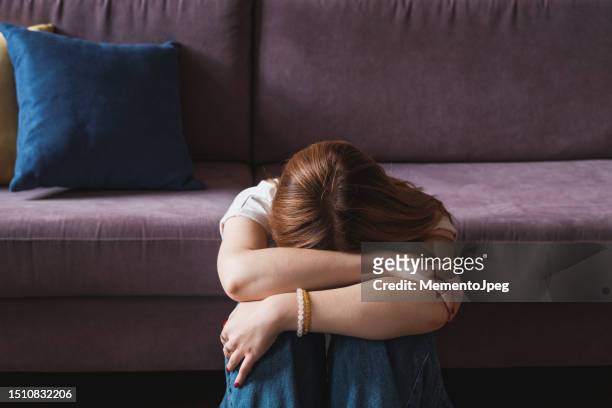 upset depressed teenager girl covering face with hands and crying - crying woman stock-fotos und bilder