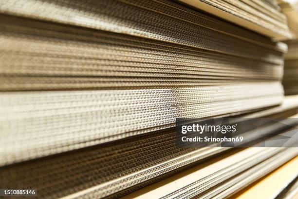 stacked corrugated boxes in a warehouse - cardboard packaging for shipping and storage in the logistics industry - papelão corrugado imagens e fotografias de stock