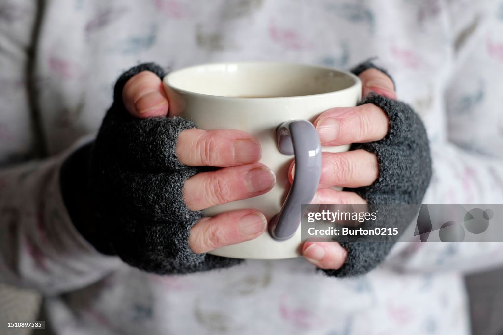 Person keeping warm holding mug