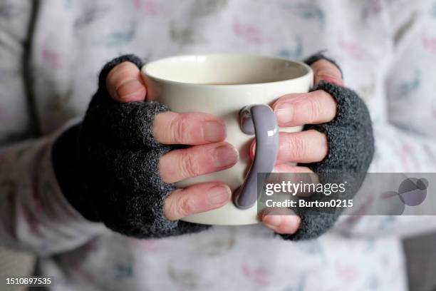 person keeping warm holding mug - fingerless glove stock pictures, royalty-free photos & images