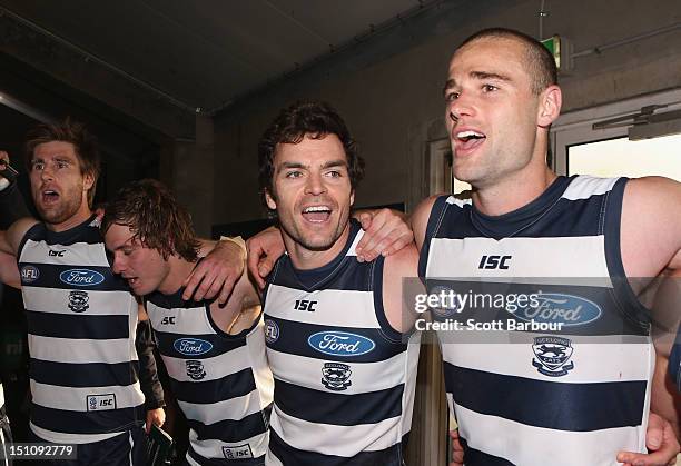 Matthew Scarlett of the Cats sings the team song in the changing room after winning the round 23 AFL match between the Geelong Cats and the Sydney...