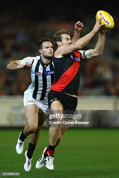 Stewart Crameri of the Bombers marks infront of Nathan Brown of the Magpies during the round 23 AFL match between the Essendon Bombers and the...