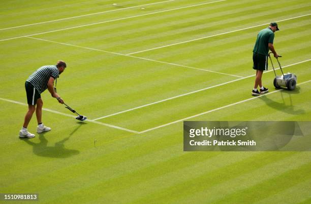 Ground staff are seen painting lines on a court prior to day one of The Championships Wimbledon 2023 at All England Lawn Tennis and Croquet Club on...