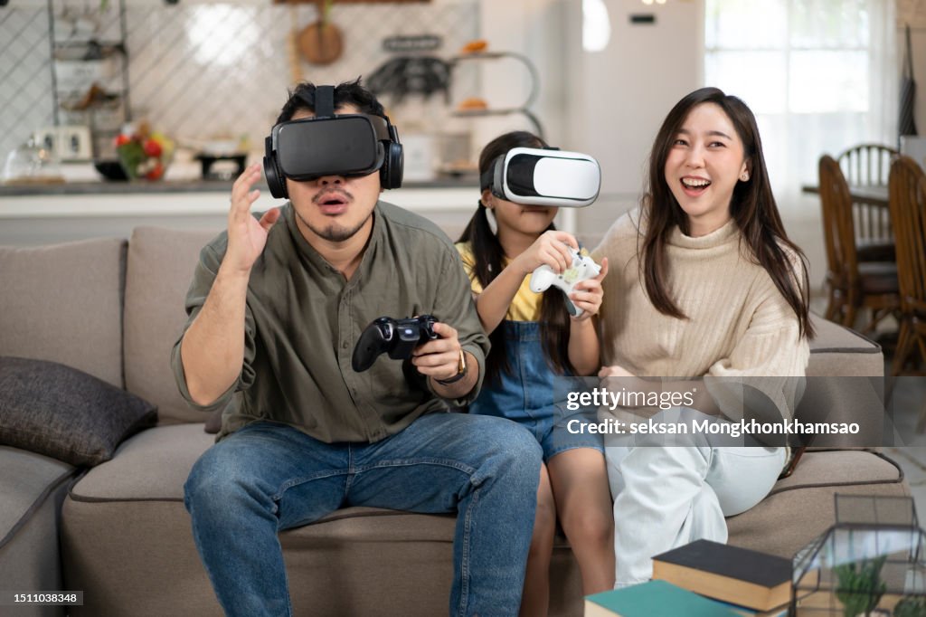 Father and son wearing the virtual reality glasses playing video game