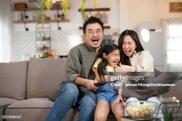 happy asian family lifestyle enjoy watching tv scary movies at home - 3 hours stock pictures, royalty-free photos & images