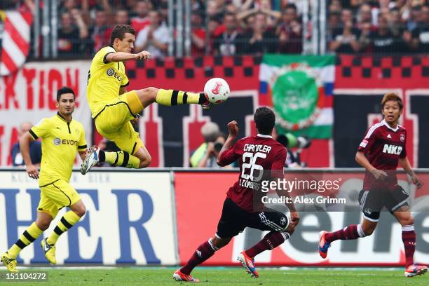 Timothy Chandler of Nuernberg is challenged by Ivan Perisic of Dortmund during the Bundesliga match between 1. FC Nuernberg and Borussia Dortmund at...
