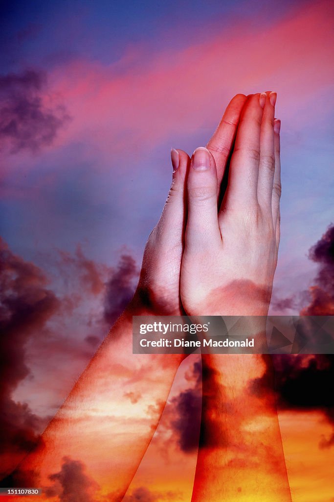Praying hands and sunset