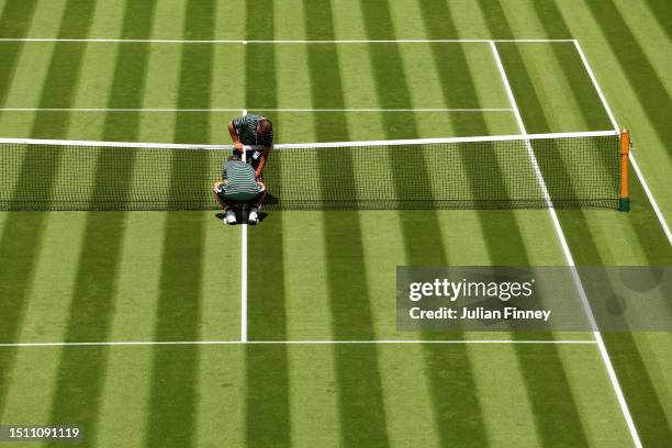 Ground Staff prepare the net on Centre Court during day one of The Championships Wimbledon 2023 at All England Lawn Tennis and Croquet Club on July...