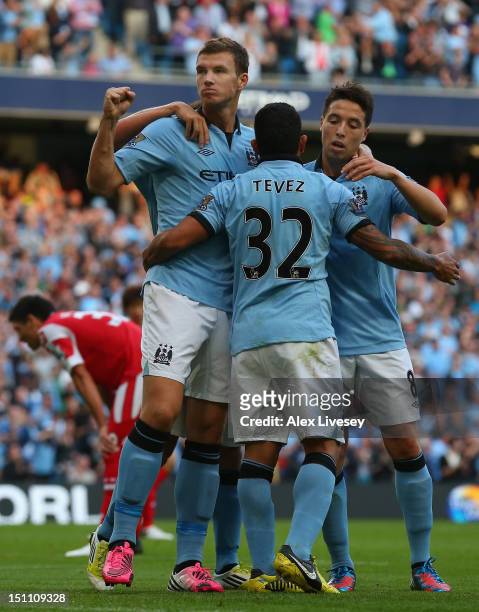 Edin Dzeko of Manchester City celebrates his goal with Carlos Tevez and Samir Nasri during the Barclays Premier League match between Manchester City...