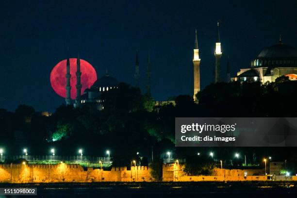 The full moon is pictured with the Hagia Sophia Mosque and the Blue Mosque on July 03, 2023 in Istanbul, Türkiye.