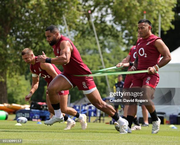 Joe Cokanasiga sprints as team mate Manu Tuilagi holds onto the tension belt during the England training session held at The Lensbury on July 03,...