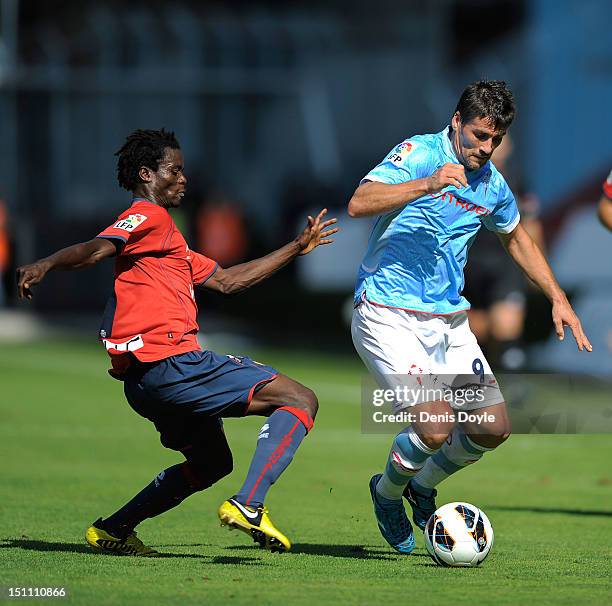 Mario Bermejo of RC Celta de Vigo is tackled by Anthony Annan of CA Osasuna during the La Liga match between RC Celta de Vigo and CA Osasuna at...