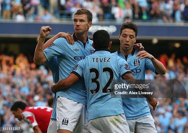 Edin Dzeko of Manchester City celebrates his goal with Carlos Tevez and Samir Nasri during the Barclays Premier League match between Manchester City...