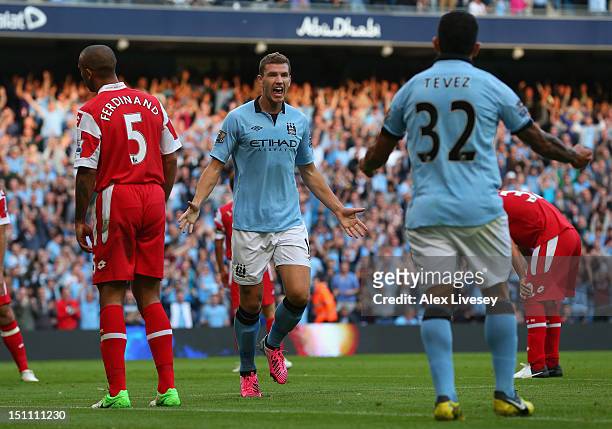 Edin Dzeko of Manchester City celebrates his goal with Carlos Tevez during the Barclays Premier League match between Manchester City and Queens Park...