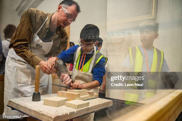 Young students are taught how to use chisels as they view the equipment displayed by the Building Crafts College during the City Careers Festival at...