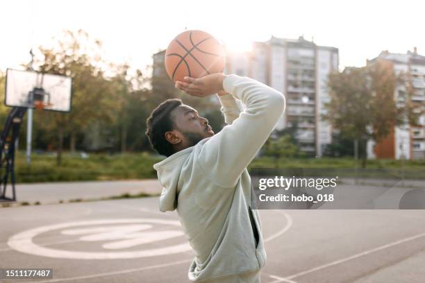 homme pratiquant seul le tir au basketball - basket ball masculin photos et images de collection
