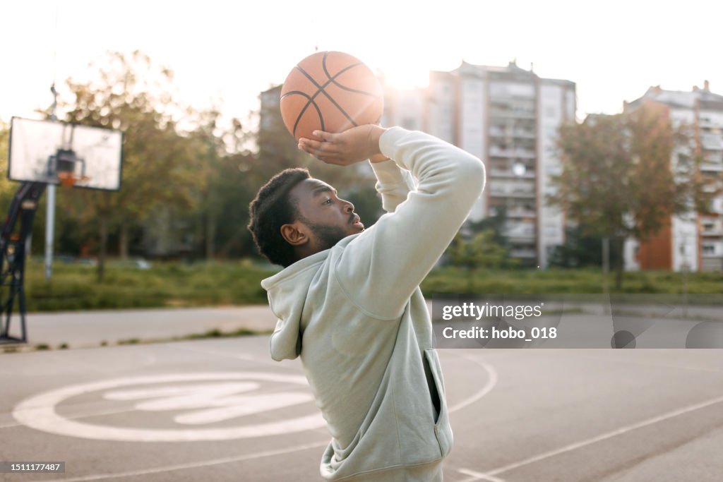 Man practicing basketball shooting alone
