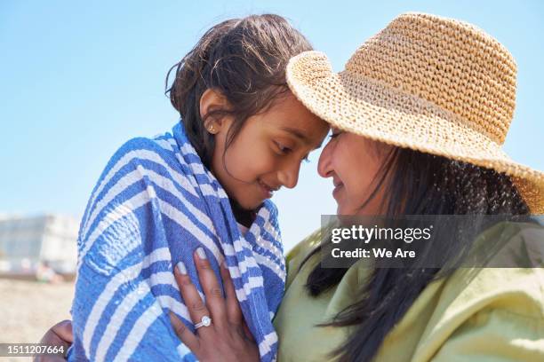 mother cuddling daughter - envuelto en una toalla fotografías e imágenes de stock