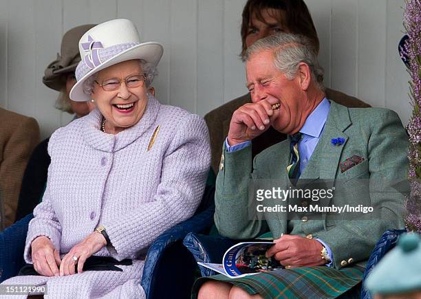 Queen Elizabeth II and Prince Charles, Prince of Wales laugh whilst watching the children's sack race as they attend the 2012 Braemar Highland...