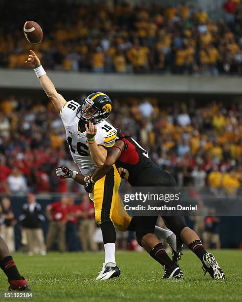 James Vandenberg of the Iowa Hawkeyes is hit while trying to pass for a two-point conversion by Sean Progar of the Northern Illinois Huskies at...