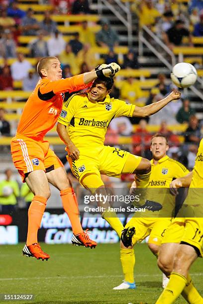 Goalkeeper Troy Perkins of the Montreal Impact punches away the ball as Jairo Arrieta of the Columbus Crew attempts to take control of the ball on a...