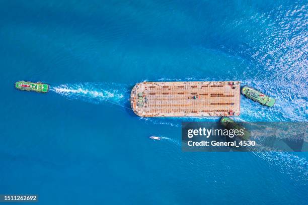 aerial top view tug boat tows empty barges with water to pass under low bridges. - tug barge stock pictures, royalty-free photos & images