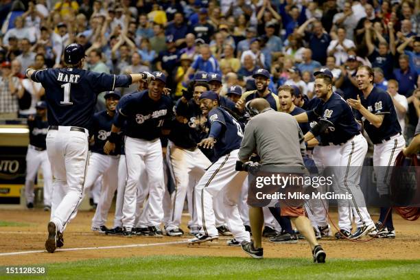 Corey Hart of the Milwaukee Brewers is awaited by the team at home plate after hitting a walk off home run in the bottom of the 9th inning putting...
