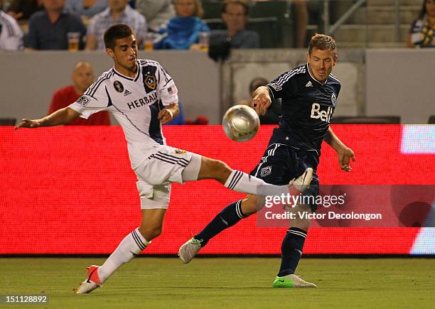 Jordan Harvey of the Vancouver Whitecaps crosses against Hector Jimenez of the Los Angeles Galaxy in the first half during the MLS match at The Home...