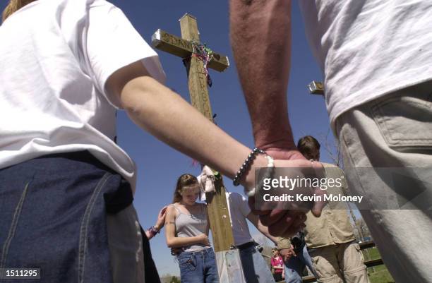 Area high school student Kristina Metter weeps during a prayer at a row of thirteen crosses in Robert F. Clement Park in Littleton, CO, April 20,...