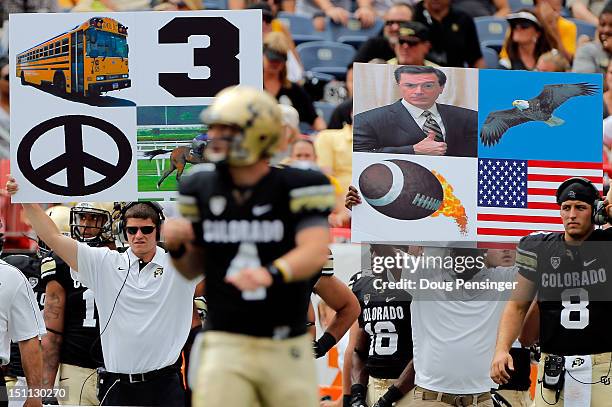 Quarterback Jordan Webb of the Colorado Buffaloes returns to the huddle as play signs are displayed on his bench against the Colorado State Rams in...
