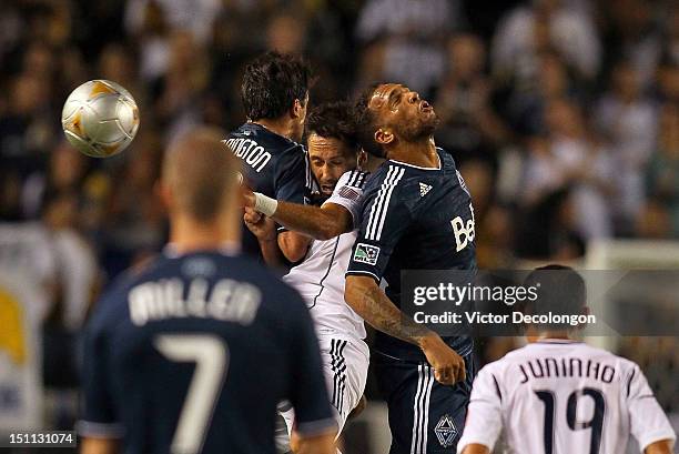 John Thorrington and Matt Watson of the Vancouver Whitecaps collide with Marcelo Sarvas of the Los Angeles Galaxy as they vie for the high ball in...