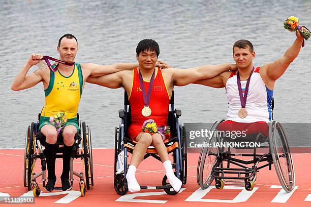 China's Cheng Huang celebrates winning the gold medal in the AS men single sculls with silver medallist Australia'a Erik Horrie and bronze medallist...