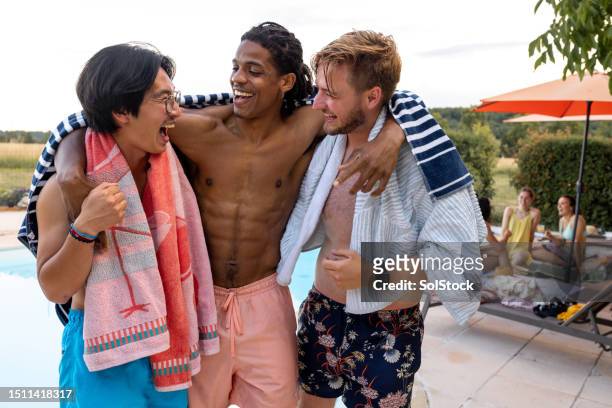laughing with friends around pool - only young men stock pictures, royalty-free photos & images