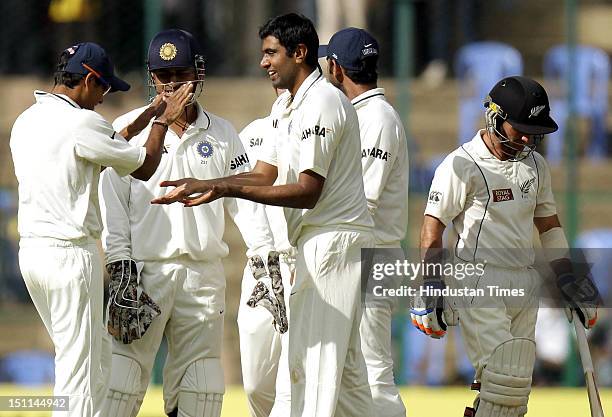 Indian bowler Ravichandran Ashwin celebrates with teammates after the dismissal of New Zealand batsman Kruger Van Wyk during third day of second Test...