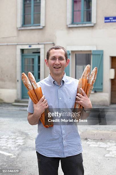 man holding baguette - typique de la france photos et images de collection