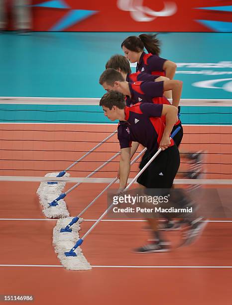 Volunteers wipe the court during a time out in the Men's Sitting Volleyball Preliminary Round Pool A match between Great Britain and Morocco on day 4...