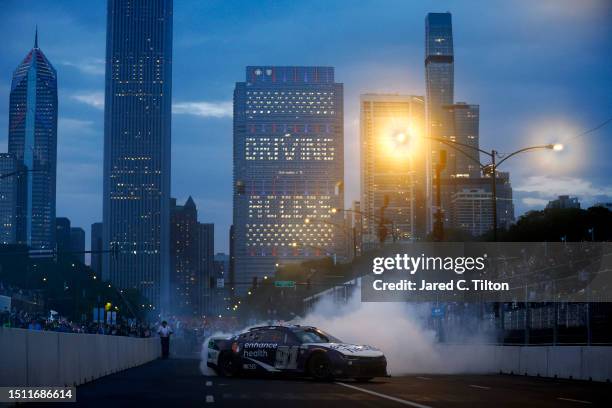 Shane Van Gisbergen, driver of the Enhance Health Chevrolet, celebrates with a burnout after winning the NASCAR Cup Series Grant Park 220 at the...