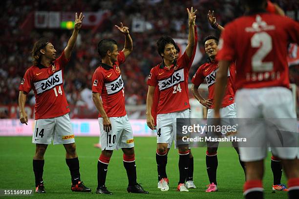 Genki Haraguchi of Urawa Red Diamonds celebrates scoring their first goal withi his team mates Tadaaki Hirakawa , Marcio Richardes during the...