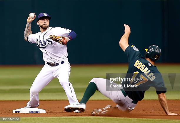 Infielder Ryan Roberts of the Tampa Bay Rays turns a double play as Adam Rosales of the Oakland Athletics tries to break it up during the game at...