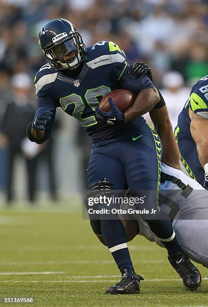 Running back Kregg Lumpkin of the Seattle Seahawks rushes against Jack Crawford of the Oakland Raiders at CenturyLink Field on August 30, 2012 in...