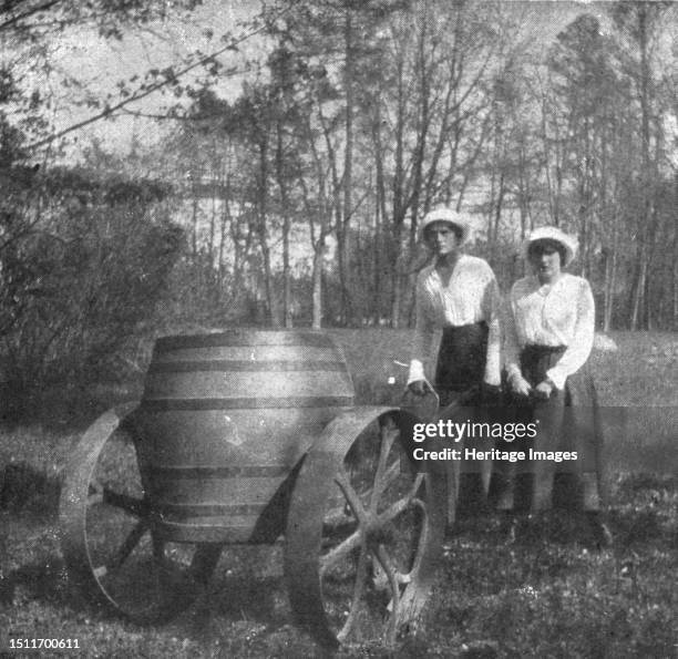 ''Les Romanof a Tsarskoie-Selo; Les grandes-duchesses Tatiana et Anastasie poussant un tonneau d'arrosage', 1917. From "L'Album de la Guerre...